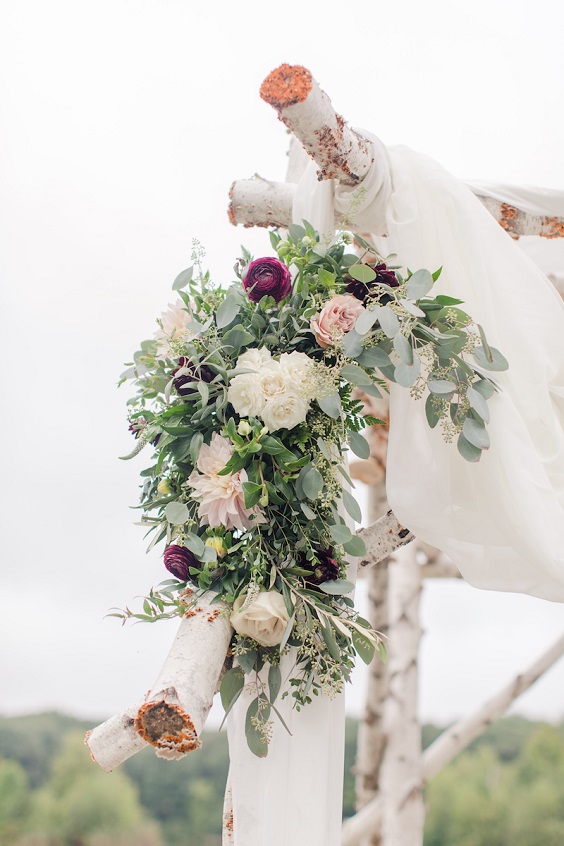 wooden ceremony arch with burgundy and blush flowers and greenery for burgundy wedding colors for 2025 burgundy and blush