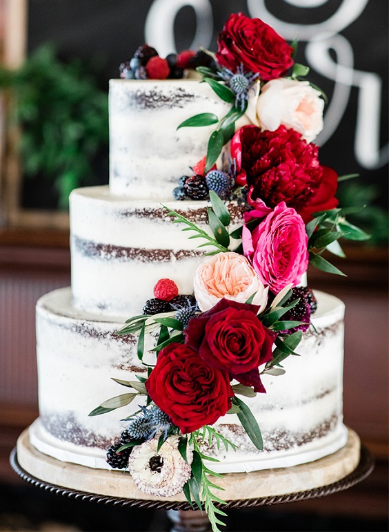 nude wedding cake dotted with burgundy flowers and blueberries for burgundy wedding colors for 2025 burgundy and navy blue