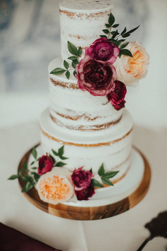 nude wedding cake dotted with burgundy and peach flower for burgundy wedding colors for 2025 burgundy and peach