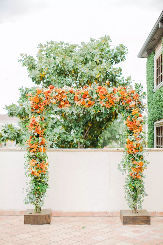 wedding arch with orange flowers for may wedding colors combos for 2025 orange and yellow