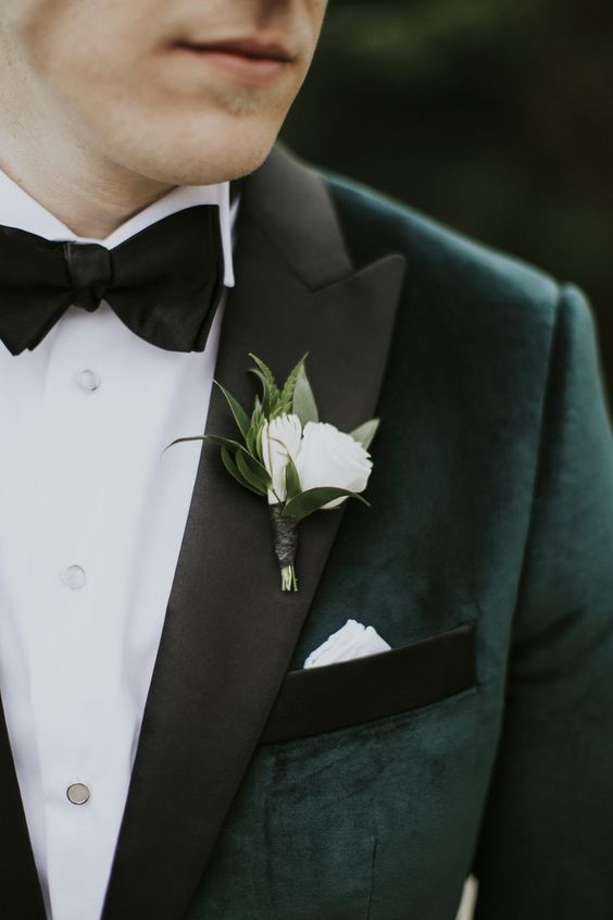 a dark green grooms attire and a white flower for april wedding colors combos for 2025 dark green and white