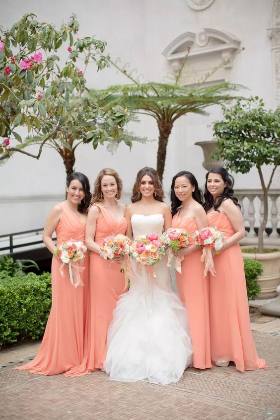 peach bridesmaid dresses and a white wedding gown for april wedding colors combos for 2025 peach mango and pink