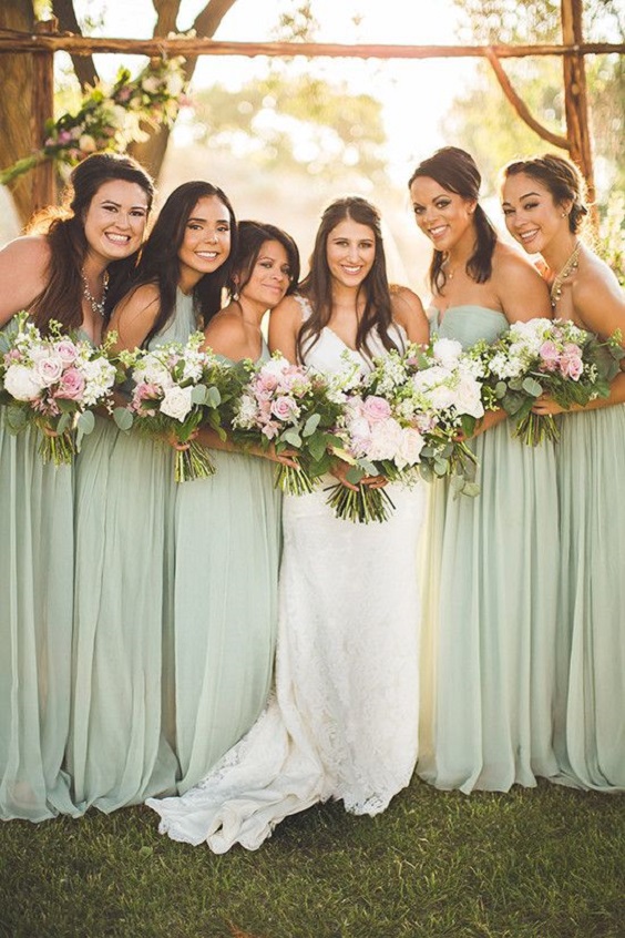 sage green bridesmaid dresses and a white bridal gown for april wedding colors combos for 2025 sage green and pink