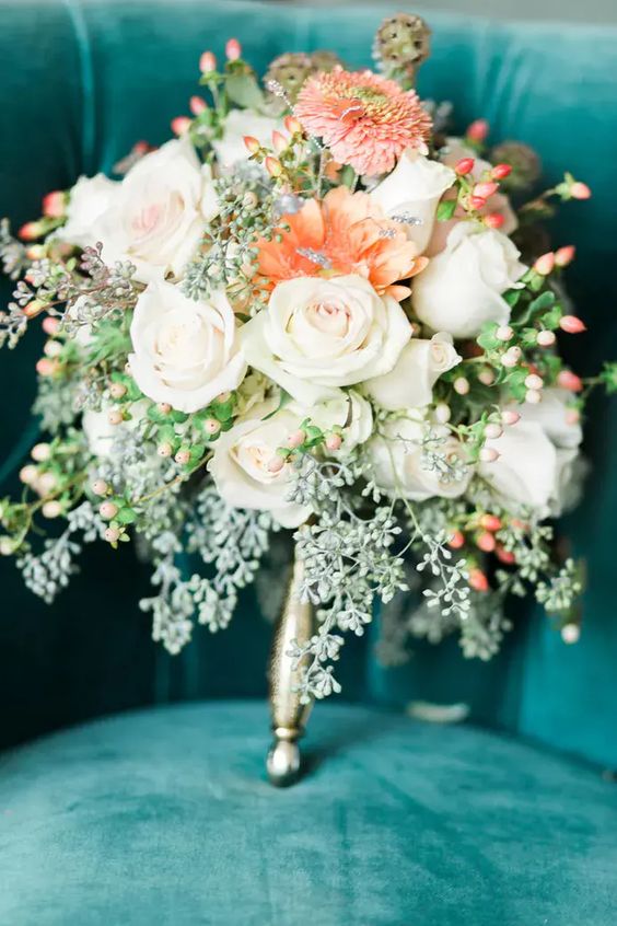 peach and white bridal bouquet on teal sofa for teal wedding colors for 2025 teal peach and greenery