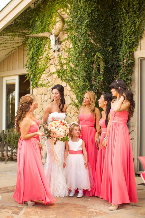 coral bridesmaid dresses and a white bridal gown and a white junior bridesmaid dress with coral sash for july wedding colors combos for 2025 coral pink and orange