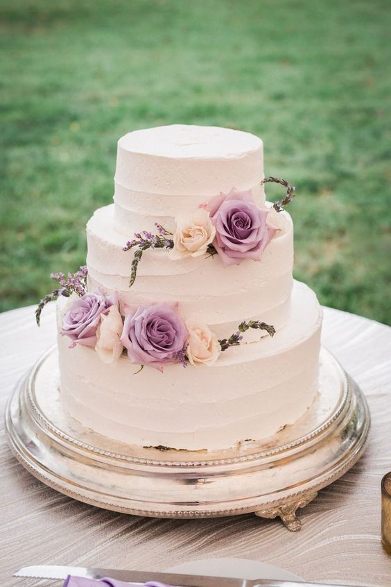 a wedding cake with light purple and pink flowers for july wedding colors combos for 2025 light purple and pink