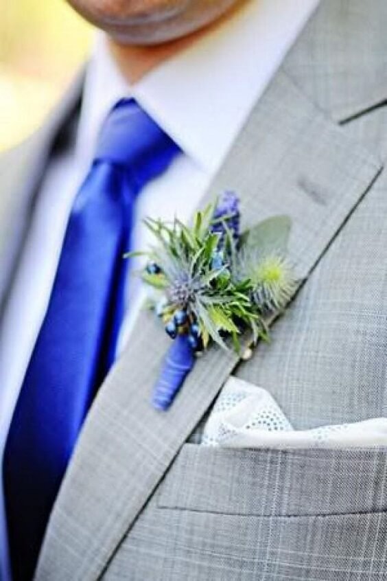 light gray grooms suit and royal blue tie and a boutonniere of thistle for summer royal blue wedding