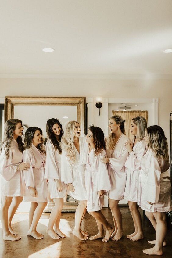 bride and bridesmaids in white robes for fall boho chic dusty rose wedding